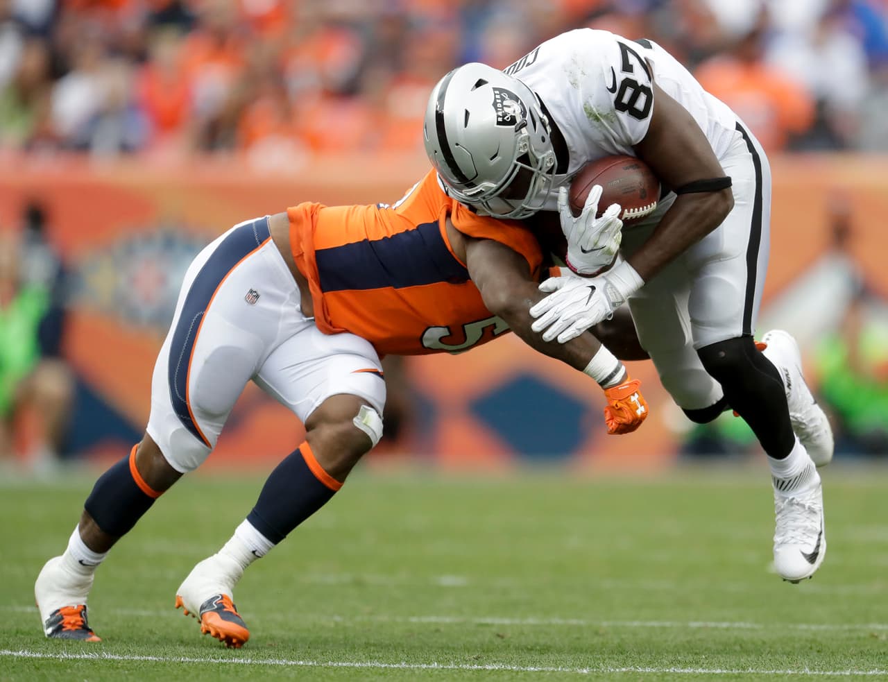 El linebacker de los Broncos de Denver, Todd Davis, taclea al tight end de los Raiders de Oakland, Jared Cook, en la segunda mitad del juego del domingo 1 de octubre de 2017 en Denver. (AP Foto/Joe Mahoney)