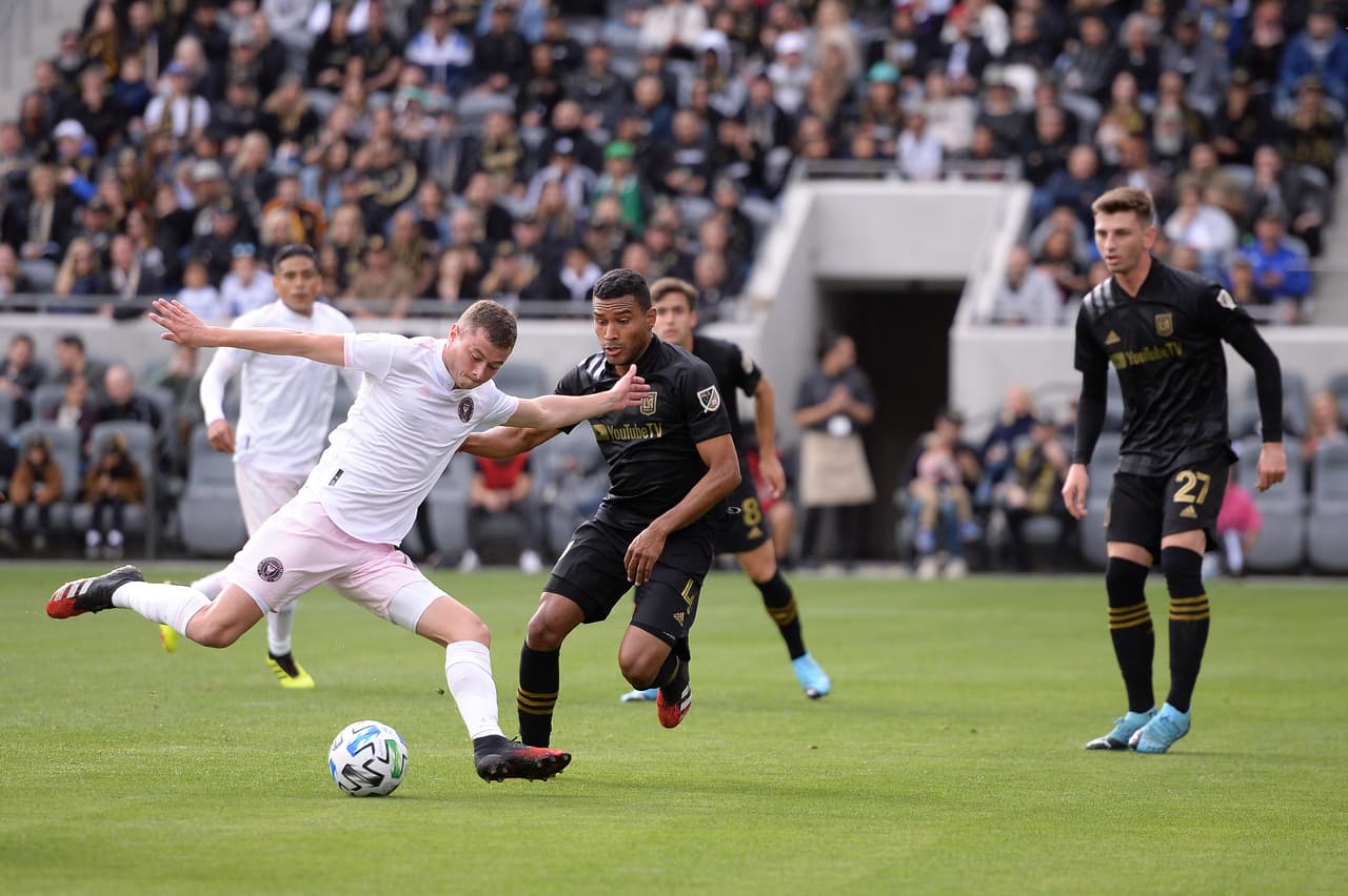 Matias Pellegrini lucha cuerpo a cuerpo con Eddie Segura por el balón, el del LAFC mira cómo su rival toca para un compañero.