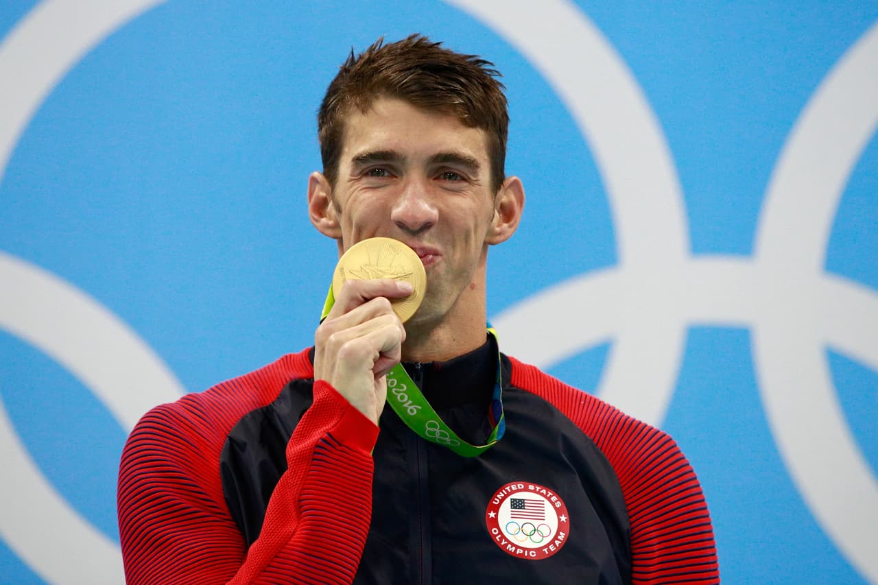 RIO DE JANEIRO, BRAZIL - AUGUST 11: Gold medalist Michael Phelps of the United States celebrates on the podium during the medal ceremony for the Men's 200m Individual Medley Final on Day 6 of the Rio 2016 Olympic Games at the Olympic Aquatics Stadium on August 11, 2016 in Rio de Janeiro, Brazil. (Photo by Adam Pretty/Getty Images)