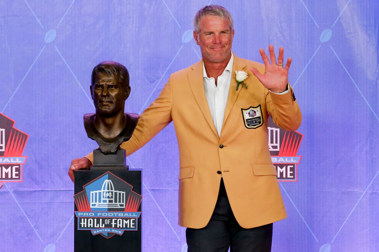 Former NFL player Brett Favre poses with a bust of himself during an induction ceremony at the Pro Football Hall of Fame Saturday, Aug. 6, 2016, in Canton, Ohio. (AP Photo/Gene J. Puskar)