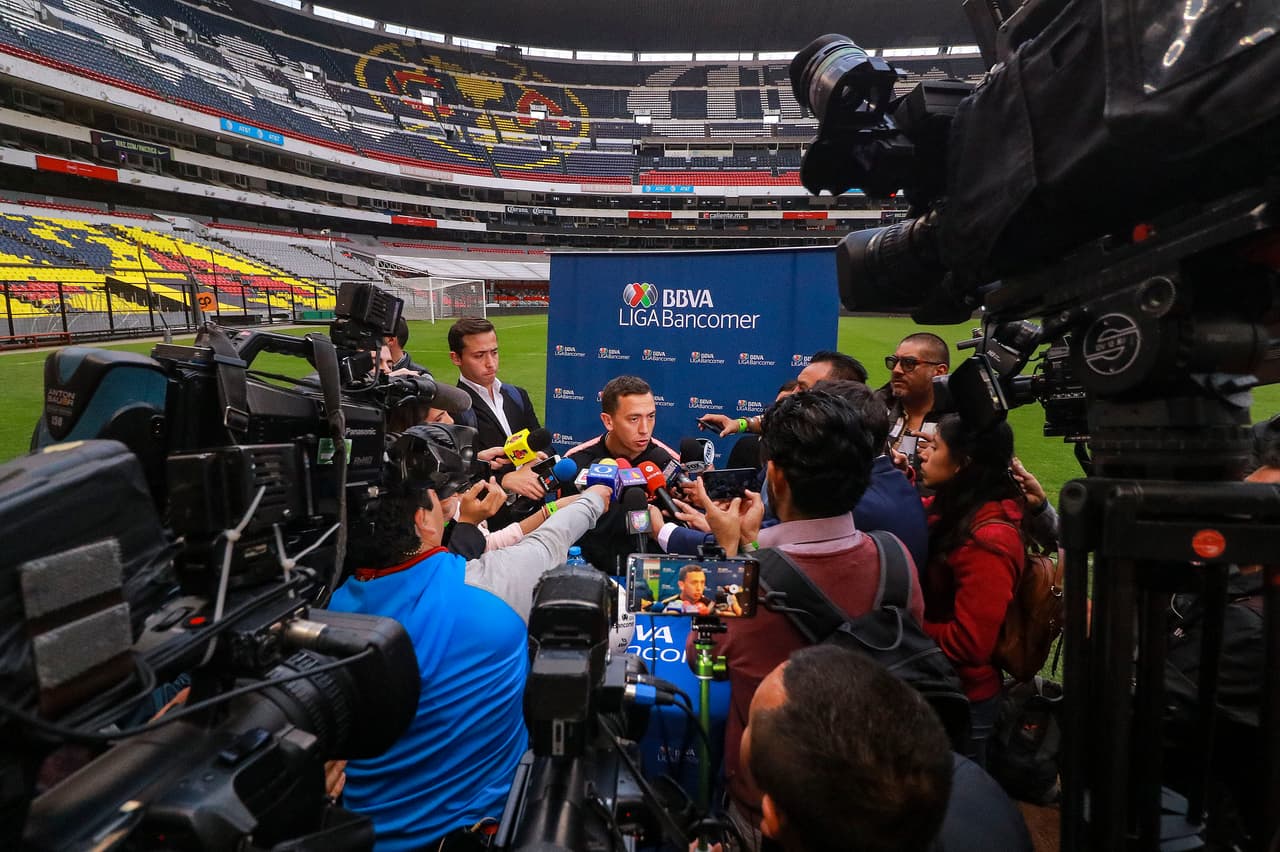 En medio de una nube de micrófonos y cámaras aparece al findo Agustín Marchesín, portero del América.