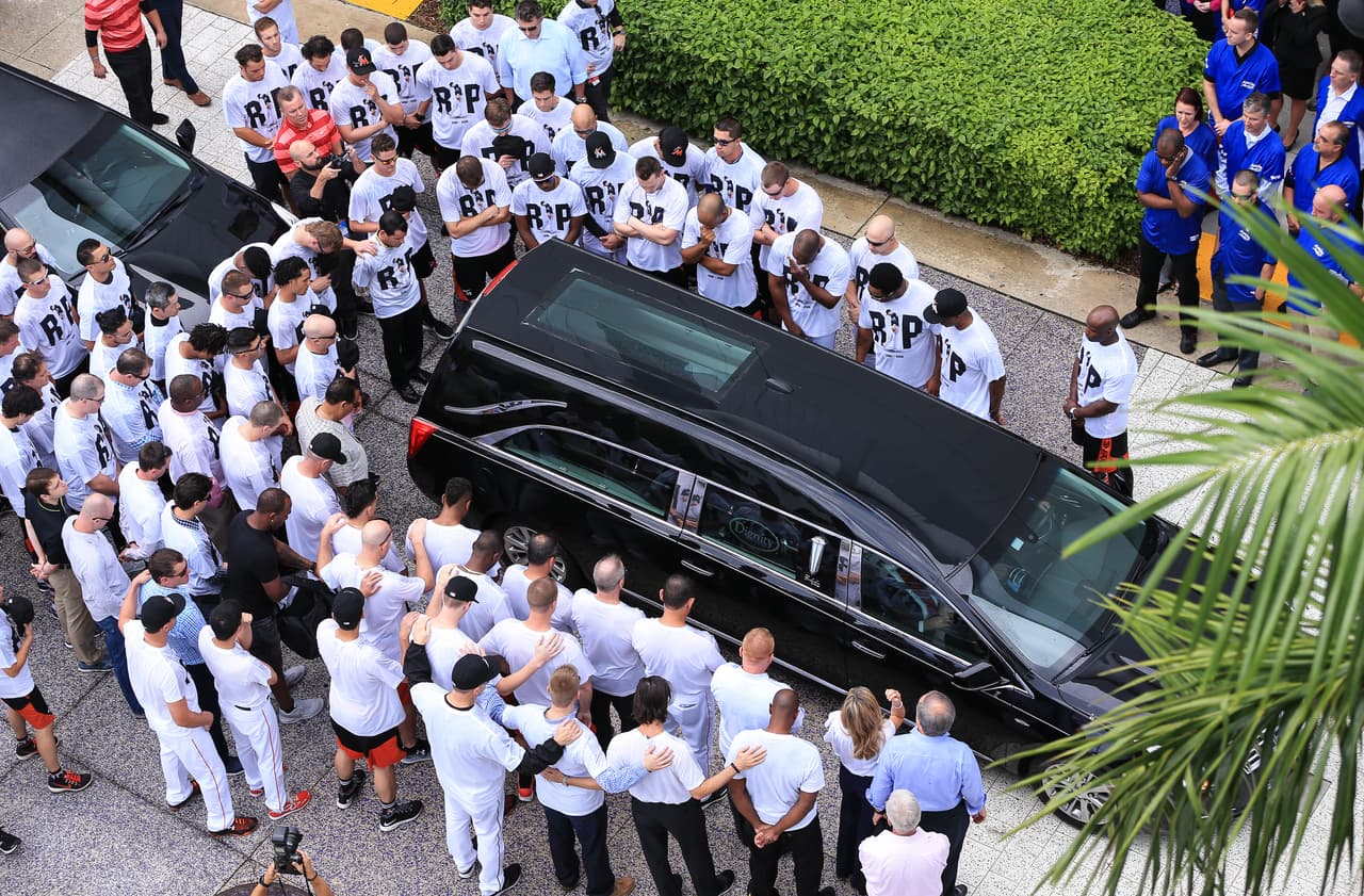 Los jugadores, directivos y fanáticos de los Marlins de Miami rodean el carro fúnebre que trasladó el cuerpo de José Fernández.
