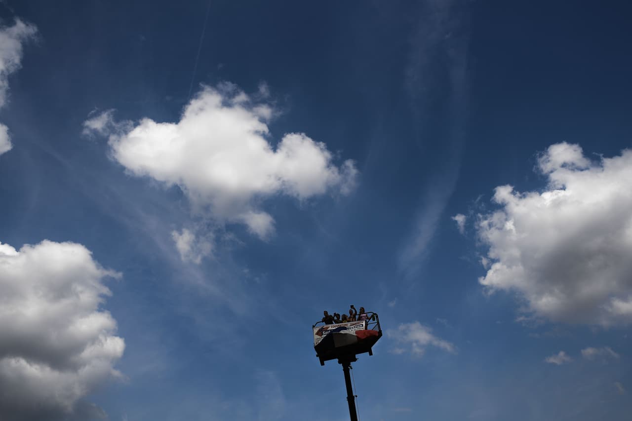 Algunos aficionados hacían lo que fuese posible para ver desde un mejor ángulo la etapa, como estos en una grúa.