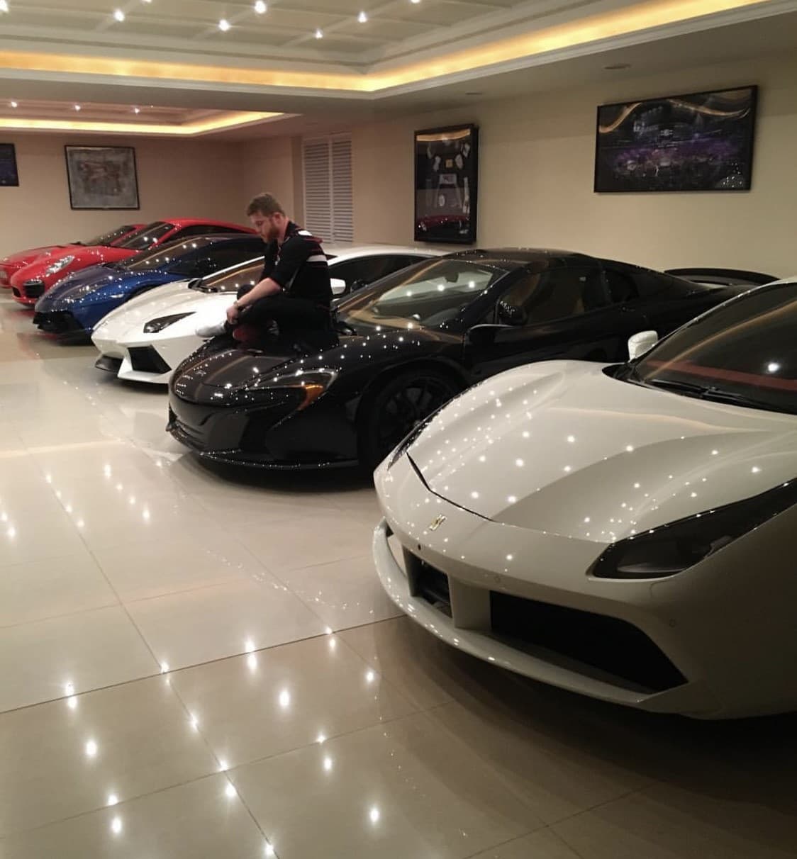 El canelo modela junto a una impresionante parte de su preciada colección de autos.