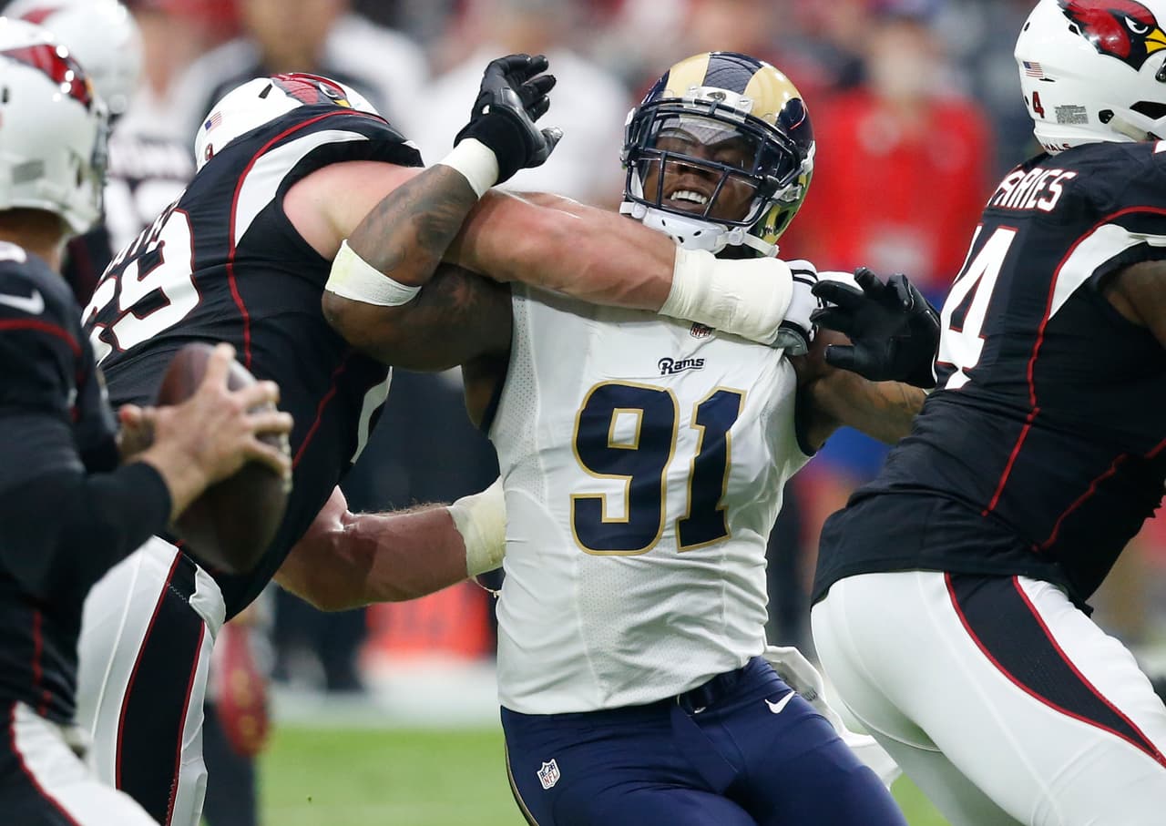 Los Angeles Rams defensive tackle Dominique Easley (91) is held back by Arizona Cardinals guard Evan Mathis during the first half of an NFL football game, Sunday, Oct. 2, 2016, in Glendale, Ariz. (AP Photo/Ross D. Franklin)