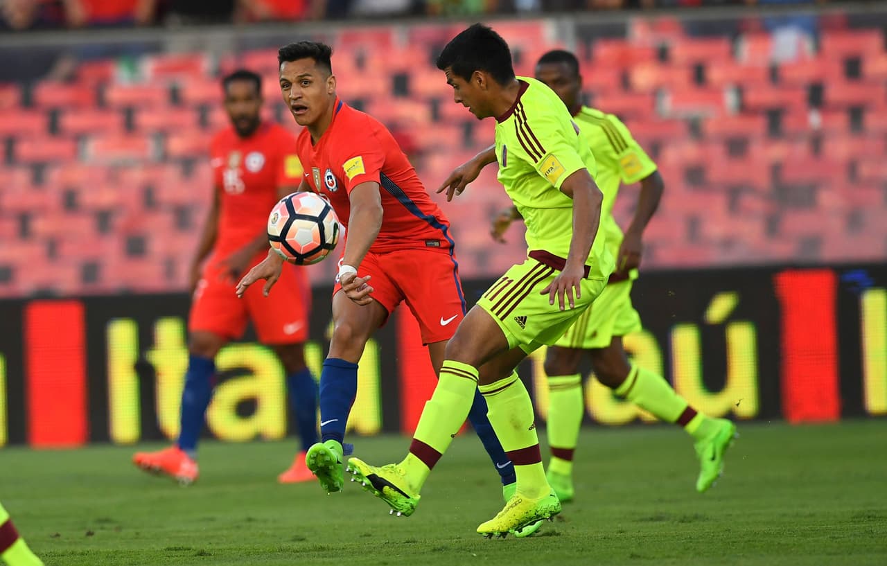 Chile's forward Alexis Sanchez (L) and Venezuela's midfielder Renzo Zambrano vie for the ball during their 2018 FIFA World Cup qualifier football match in Santiago, Chile on March 28, 2017. / AFP PHOTO / Martin BERNETTI (Photo credit should read MARTIN BERNETTI/AFP/Getty Images)