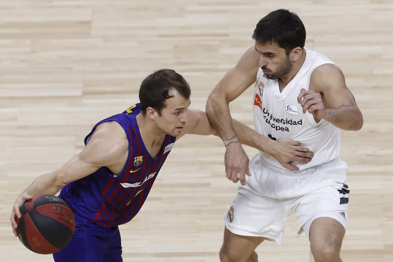 El base canadiense del FC Barcelona Lassa, Kevin Pangos (izquierda), con el balón ante la defensa del jugador argentino del Real Madrid, Facundo Campazzo (derecha).