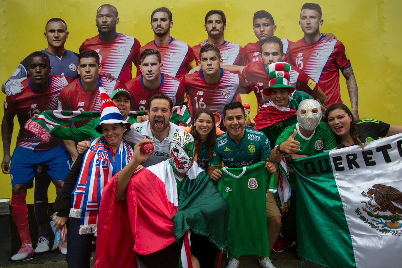 Una fotografía para el recuerdo de estos mexicanos con el poster del equipo rival.