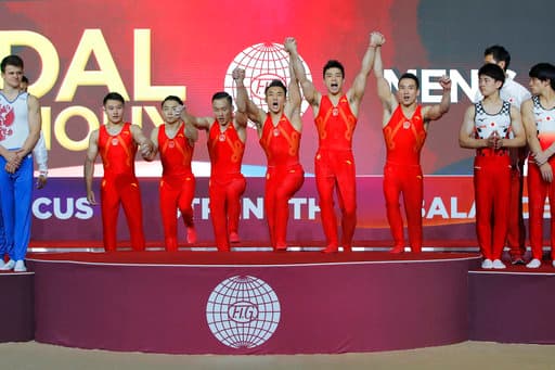 Deng Shudi, Lin Chaopan, Sun Wei, Xiao Ruoteng y Zou Jingyuan, suben al podio luego de ganar la final por equipos para hombres en el Mundial de Gimnasia en Qatar, llevándose el oro.