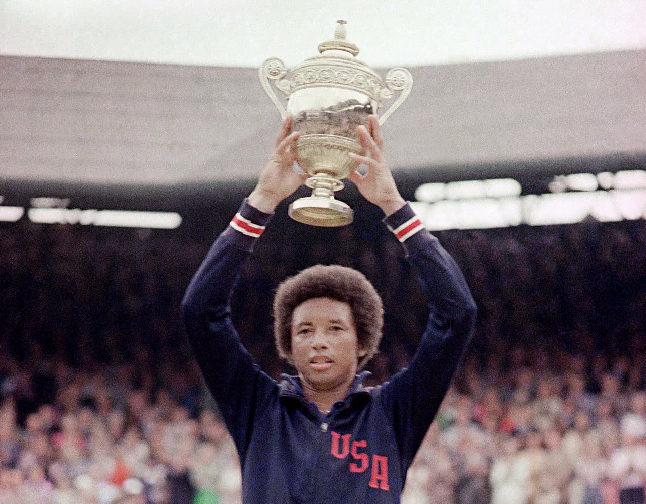 Arthur Ashe levanta el trofeo en Wimbledon.