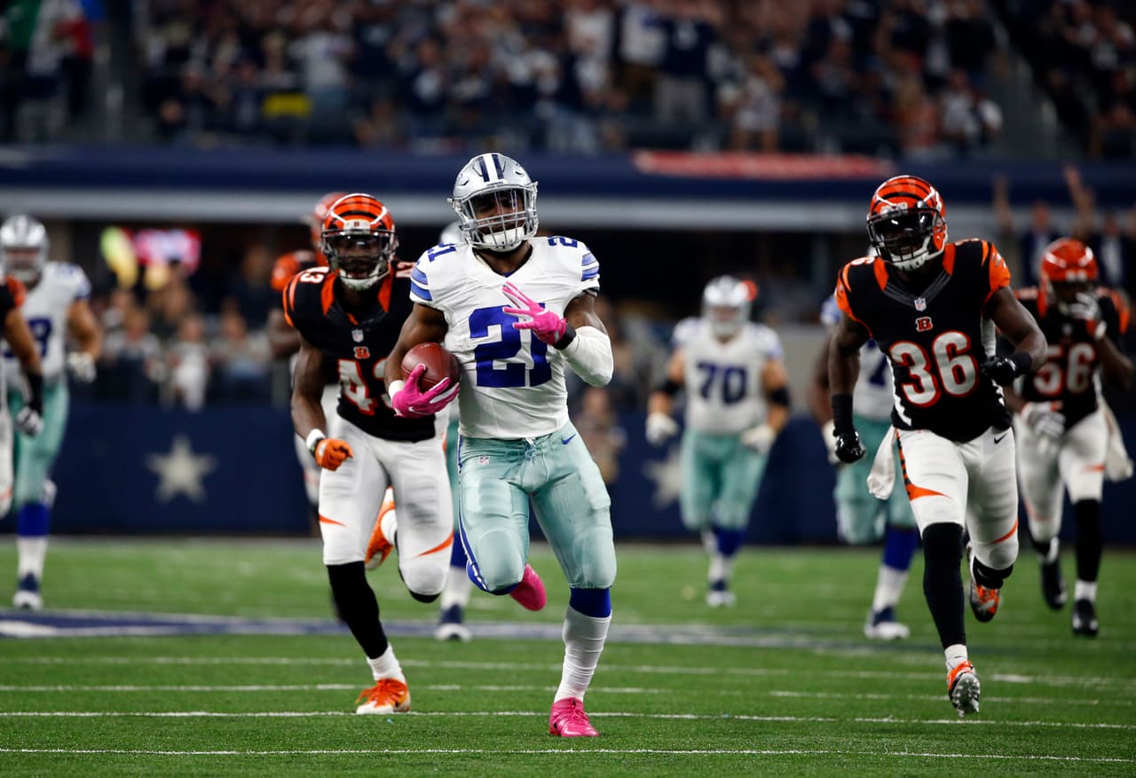 Dallas Cowboys running back Ezekiel Elliott (21) leads Cincinnati Bengals' George Iloka (43) and Shawn Williams (36) on a long run to the end zone for a touchdown in the second half of an NFL football game, Sunday, Oct. 9, 2016, in Arlington, Texas. (AP Photo/Ron Jenkins)