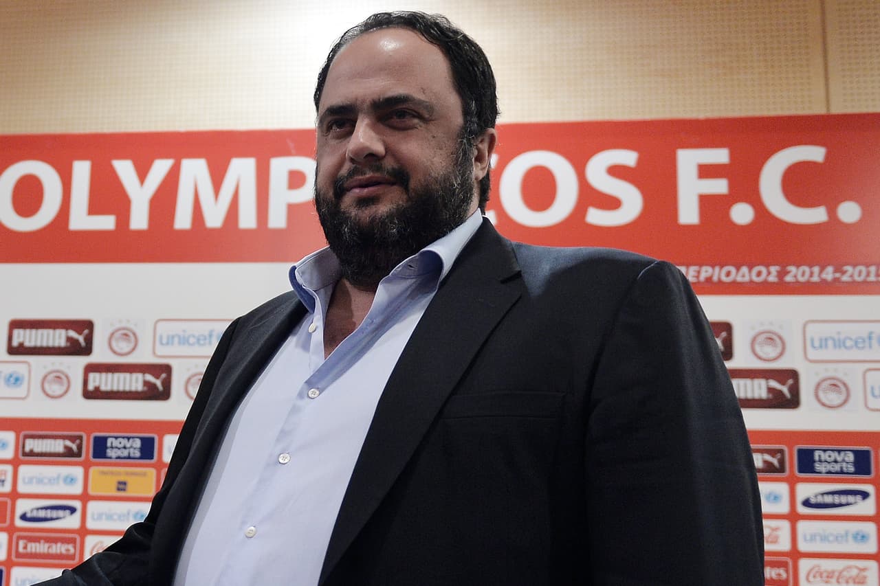 French footballer Eric Abidal (L) shakes hands with Olympikos president, Vangelis Marinakis during a press conference at Olympiakos' Karaiskaki Stadium in Piraeus near Athens on December 19, 2014. Former France international defender Eric Abidal announced his retirement on December 19 for "strictly personal reasons". But the 35-year-old former Barcelona star, who returned to playing football after undergoing a liver transplant, told an emotional press conference: "I am open to proposals.". AFP PHOTO/ LOUISA GOULIAMAKI (Photo credit should read LOUISA GOULIAMAKI/AFP/Getty Images)