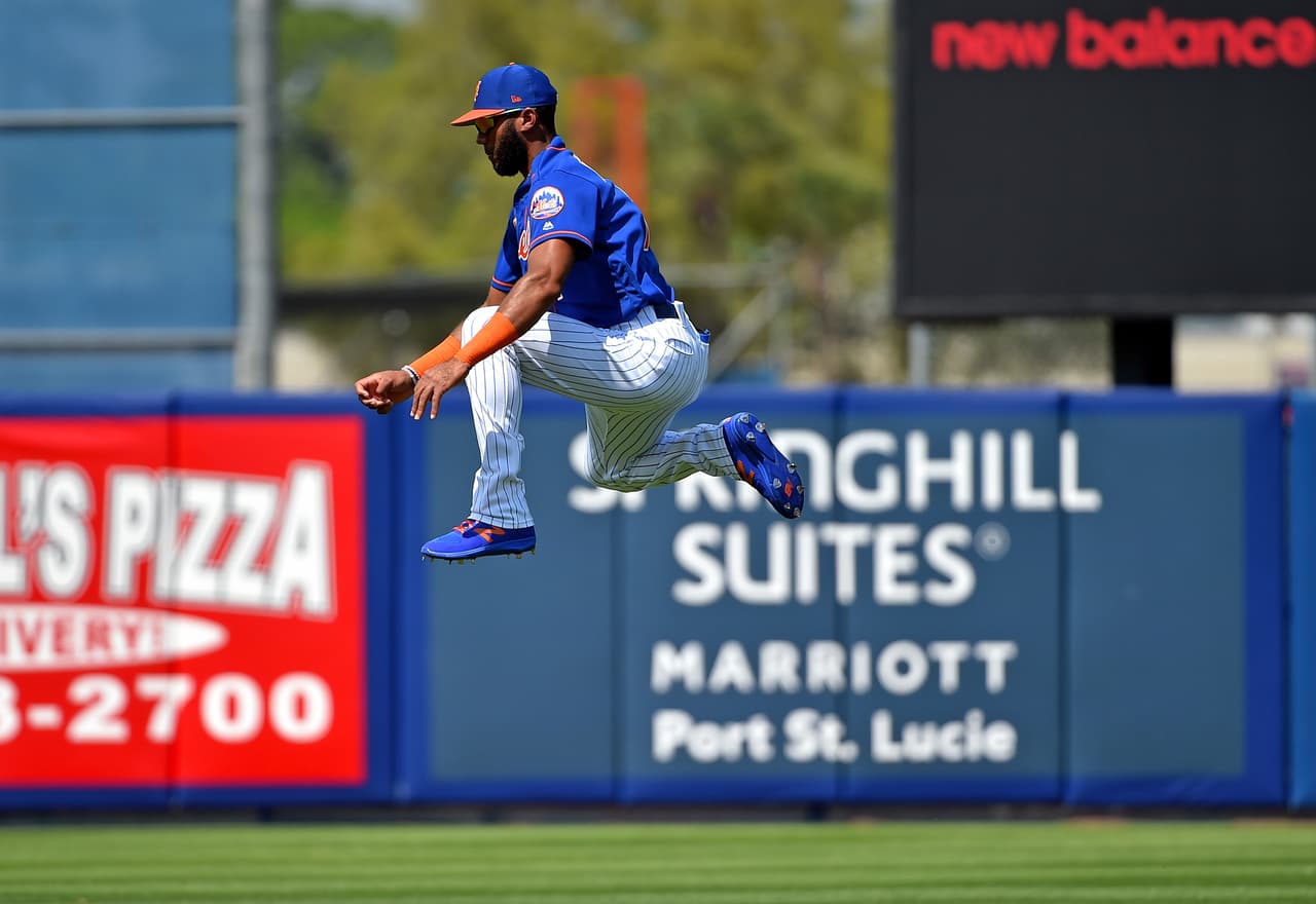 El parador en corto de los New York Mets Amed Rosario parece suspenderse en el aire, mientras hace calentamientos previo a su partido de pretemporada ante los Boston Red Sox en Florida.