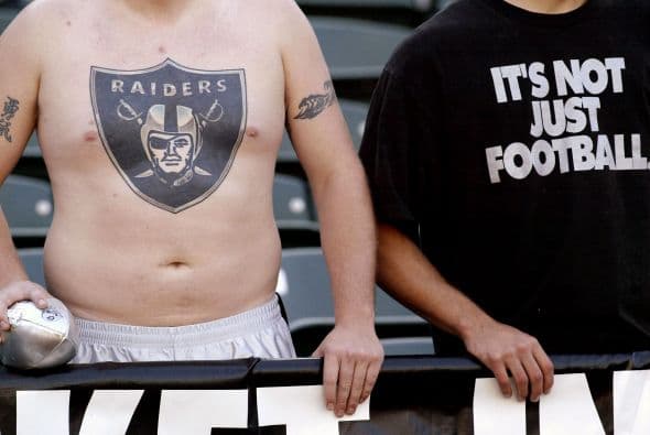 Fans de los Oakland Raiders, entre ellos uno con un tatuaje en el pecho, para ver los calentamientos antes del juego.