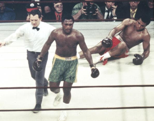 Sport, Boxing, World Heavyweight Championship, New York, pic: 8th March 1971, Joe Frazier, USA, left, led to a neutral corner by the referee after Frazier floored Ali in the 15th round, on his way to beating Muhammad Ali to retain the title, The epic fight ending with Frazier gaining a unanimous points victory (Photo by Rolls Press/Popperfoto/Getty Images)