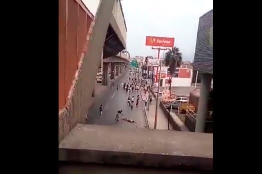 En esta imagen uno de los agresores señala al fanático de Tigres, yacido en el pavimento.