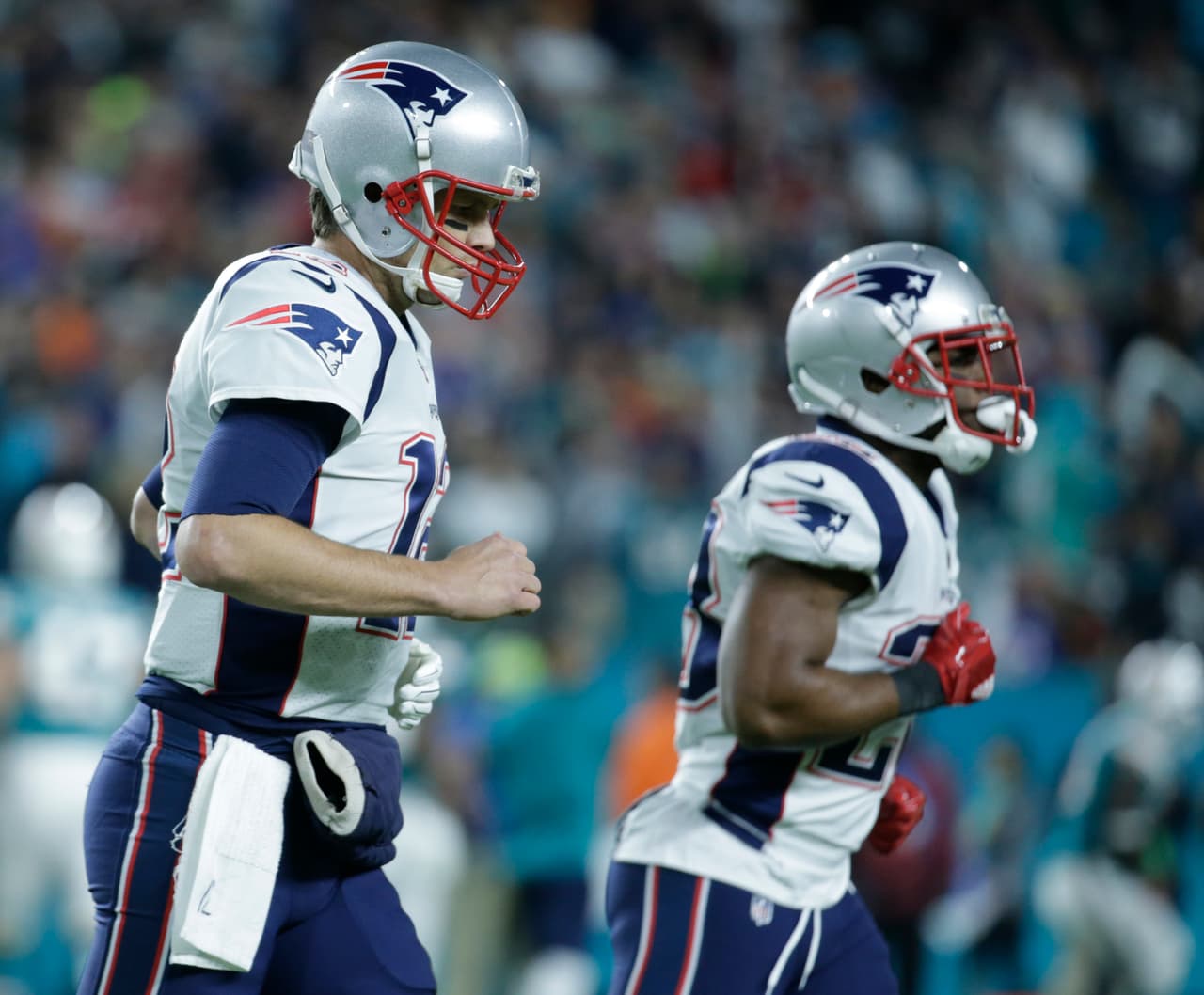 New England Patriots quarterback Tom Brady (12) and strong safety Patrick Chung (23), leave the field after a pass by Brady was intercepted by Miami Dolphins cornerback Xavien Howard (25), during the first half of an NFL football game, Monday, Dec. 11, 2017, in Miami Gardens, Fla. (AP Photo/Lynne Sladky)