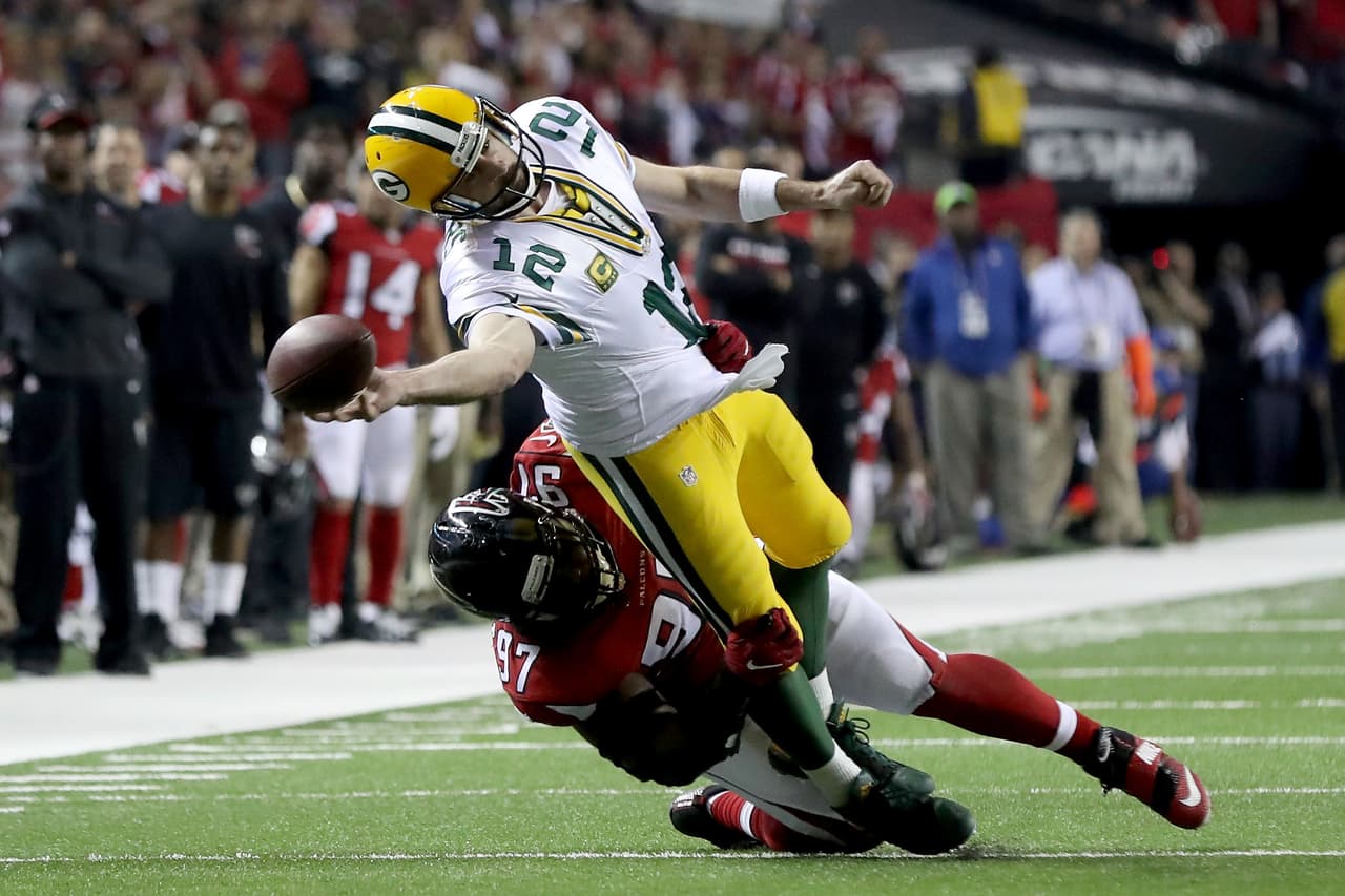 ATLANTA, GA - JANUARY 22: Aaron Rodgers #12 of the Green Bay Packers attempts a pass as he is tackled by Grady Jarrett #97 of the Atlanta Falcons in the fourth quarter in the NFC Championship Game at the Georgia Dome on January 22, 2017 in Atlanta, Georgia. (Photo by Rob Carr/Getty Images)