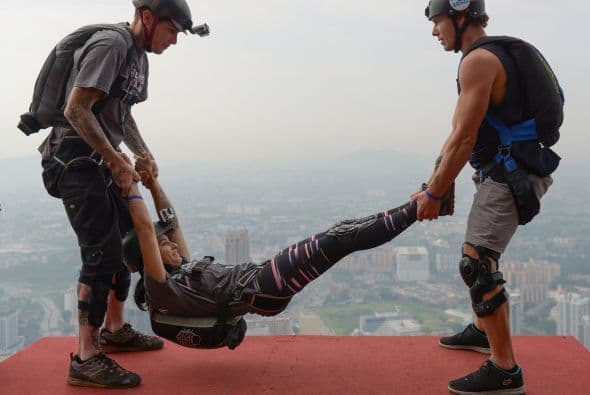 Los saltadores base Alex Borde de los EE.UU. y Jeff Weatherall de Nueva Zelanda se preparan para lanzar Clair María de los EE.UU. en su cumpleaños a unos 300 metros de altura en Malasia, Kuala Lumpur.