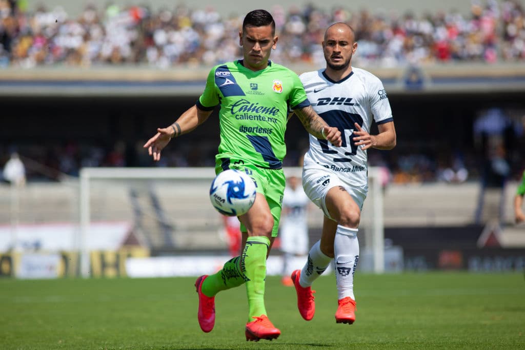 Sebastián Vegas conduce el balón por la banda pese a la marca de Carlos González que lo persigue para incomodarlo.
