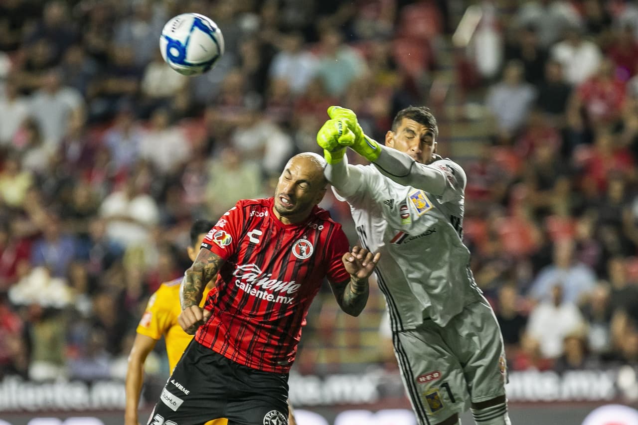Nahuel Guzmán evita la caída de su marco con una salida de puños para cortar el esférico.