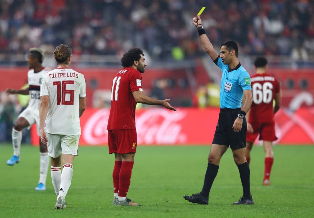 El árbitro Abdulrahman Al Jassim saca tarjeta para Mohamed Salah del Liverpool.