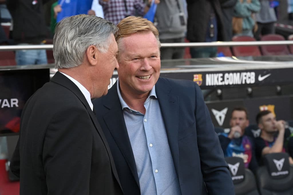 Real Madrid's Italian coach Carlo Ancelotti (L) and Barcelona's Dutch coach Ronald Koeman talk before the Spanish League football match between FC Barcelona and Real Madrid CF at the Camp Nou stadium in Barcelona on October 24, 2021. (Photo by LLUIS GENE / AFP) (Photo by LLUIS GENE/AFP via Getty Images)