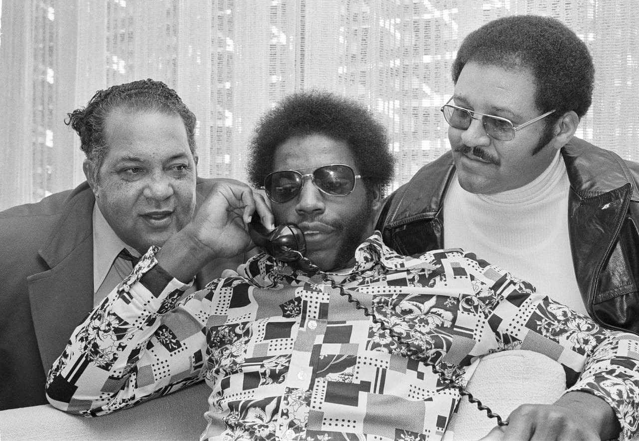 1974 ED ‘TOO TALL’ JONES | DE Tennessee State - 
<b>Dallas Cowboys</b>
<br>
<br>Ed "Too Tall" Jones, surgido de Tennessee State, el día que llegó a los Dallas Cowboys después de ser elegido como la selección número uno en el draft de la NFL, desde su hogar el 29 de enero de 1974. Acompañado por John Merritt, entrenador en jefe de Tennessee State, a la izquierda, y James Matthews, su exentrenador de la escuela secundaria, a la derecha. La llamada se hizo desde la oficina de los Cowboys en Dallas.