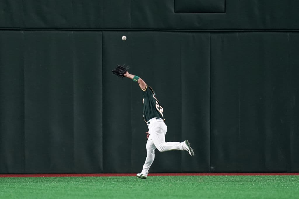 El outfielder Ramón Laureano de los Oakland Athletics hace un largo recorrido para completar una atrapada en la séptima entrada del partido entre su equipo y los Hokkaido Nippon-Ham Fighters. ¡Tremenda carrera!