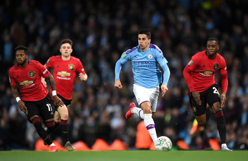 Joao Cancelo del Manchester City es presionado por Aaron Wan-Bissaka del Manchester United.