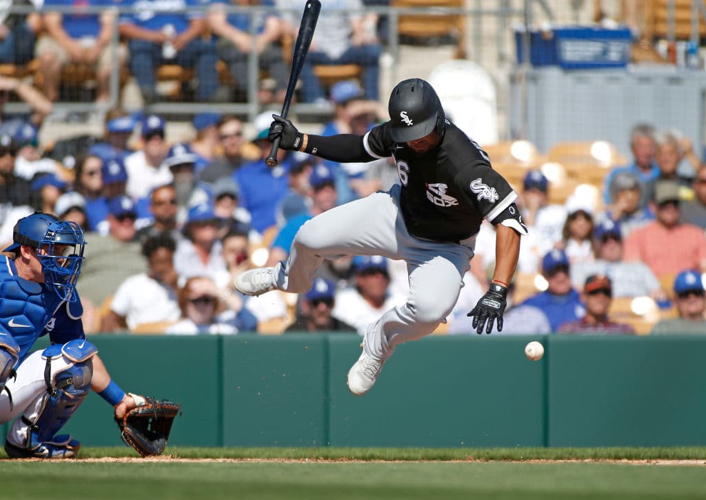 A nada de ser golpeado, Cheslor Cuthbert de los Chicago White Sox salta para evitar la pelota que viene hacia su persona desde el montículo de los Dodgers.