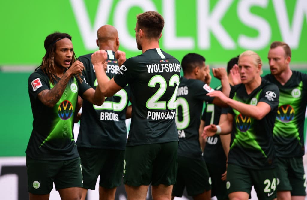 WOLFSBURG, GERMANY - MAY 30: Kevin Mbabu of VfL Wolfsburg (L) celebrates with teammates after scoring his team's first goal during the Bundesliga match between VfL Wolfsburg and Eintracht Frankfurt at Volkswagen Arena on May 30, 2020 in Wolfsburg, Germany. (Photo by Swen Pfoertner/Pool via Getty Images)