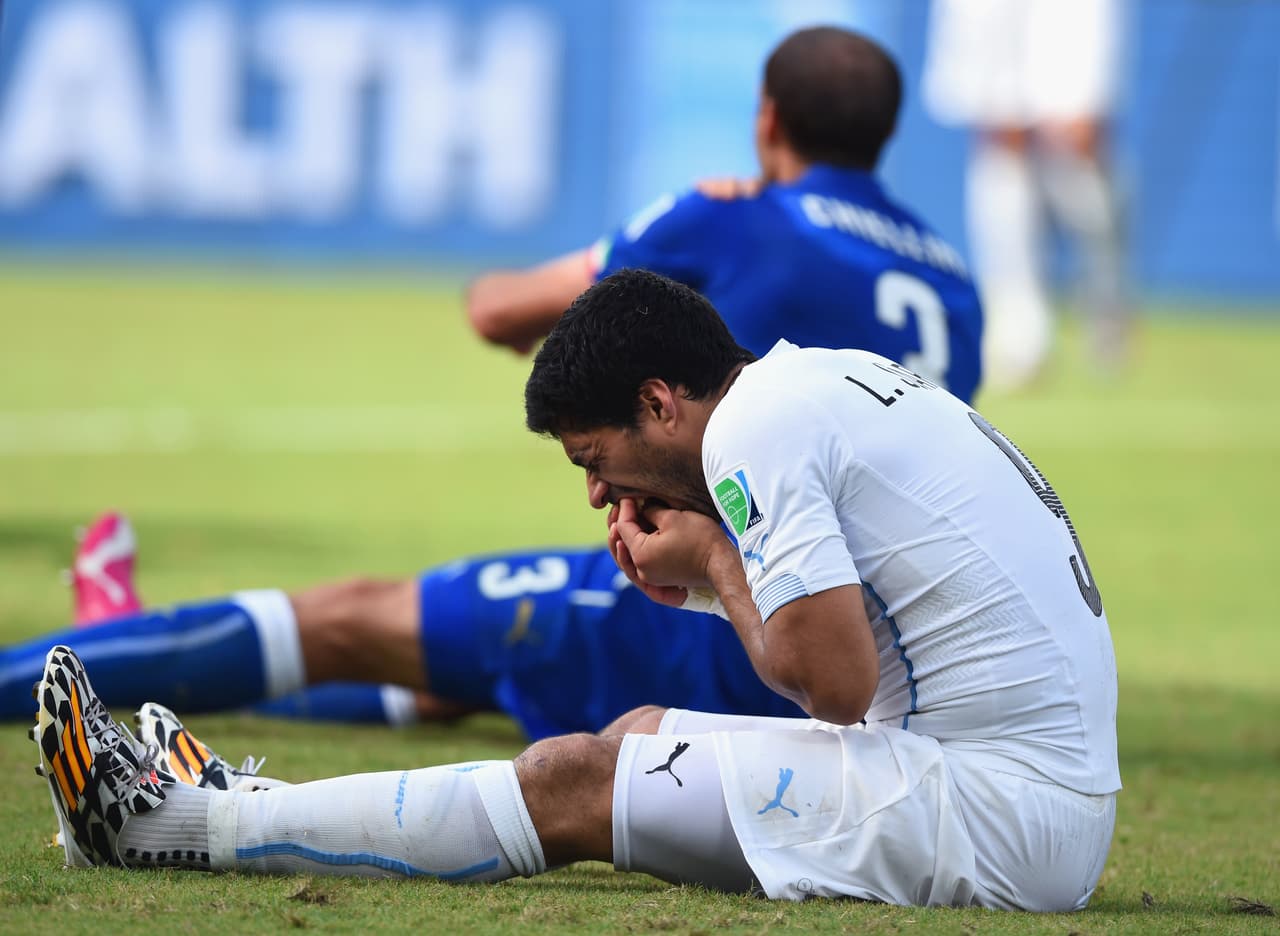 NATAL, BRAZIL - JUNE 24: Luis Suarez of Uruguay and Giorgio Chiellini of Italy react after a clash during the 2014 FIFA World Cup Brazil Group D match between Italy and Uruguay at Estadio das Dunas on June 24, 2014 in Natal, Brazil. (Photo by Matthias Hangst/Getty Images)