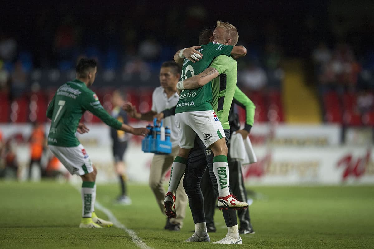 Luis Montes (centro) se abraza con un compañero al celebrar el cuarto gol del León, su doblete al minuto 88' de tiro penal.