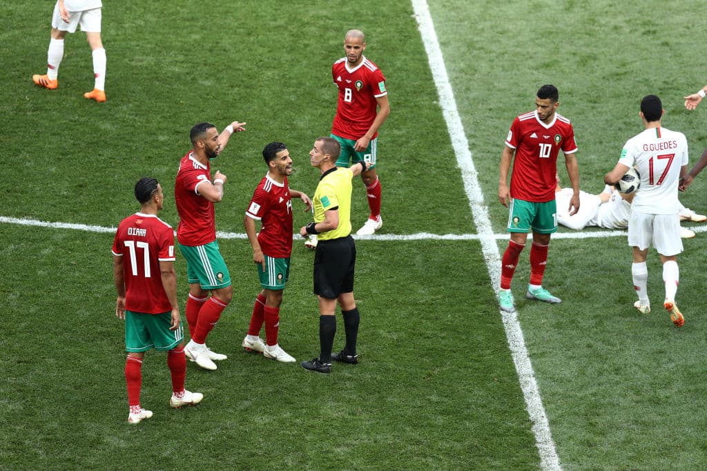 MOSCOW, RUSSIA - JUNE 20: Referee Mark Geiger shows a yellow card to Mehdi Benatia of Morocco during the 2018 FIFA World Cup Russia group B match between Portugal and Morocco at Luzhniki Stadium on June 20, 2018 in Moscow, Russia. (Photo by Maddie Meyer/Getty Images)