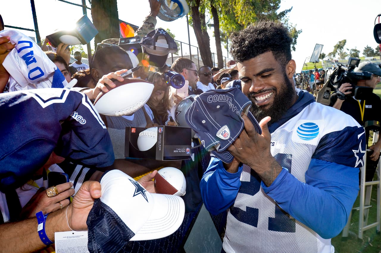 Dallas Cowboys running back Ezekiel Elliott signs autographs at the end of the day at NFL football training camp in Oxnard, Calif., Tuesday, July 25, 2017. (AP Photo/Gus Ruelas)