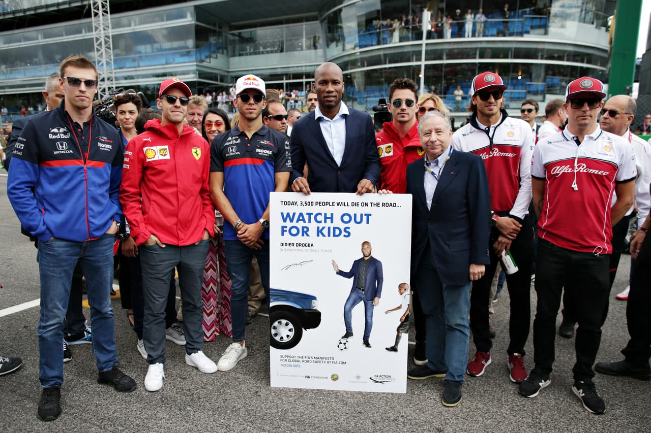 Los pilotos con Didier Drogba posan para la campaña de seguridad FIA.