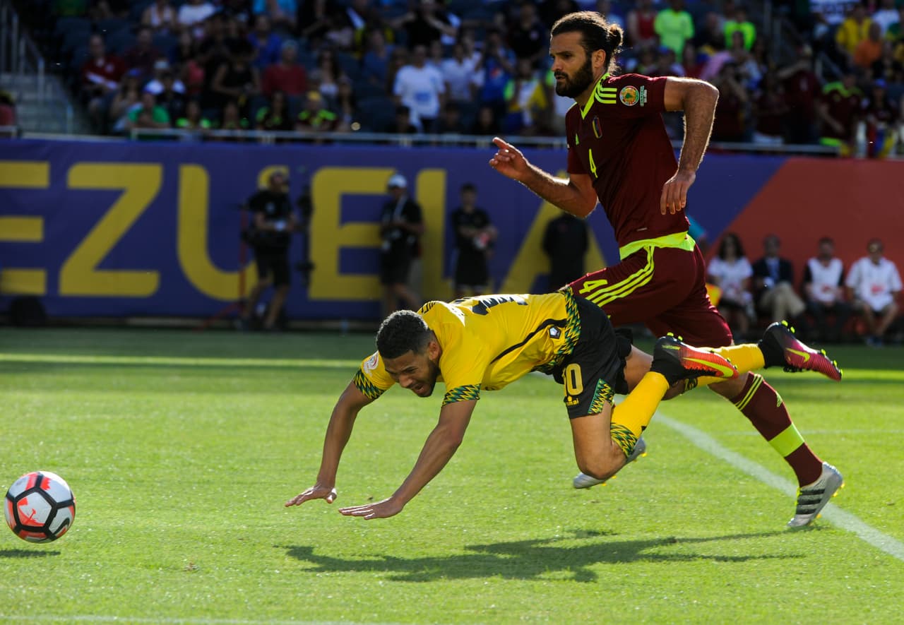 Oswaldo Vizcarrondo de Venezuela pelea el balón con Jobi McAnuff de Jamaica.