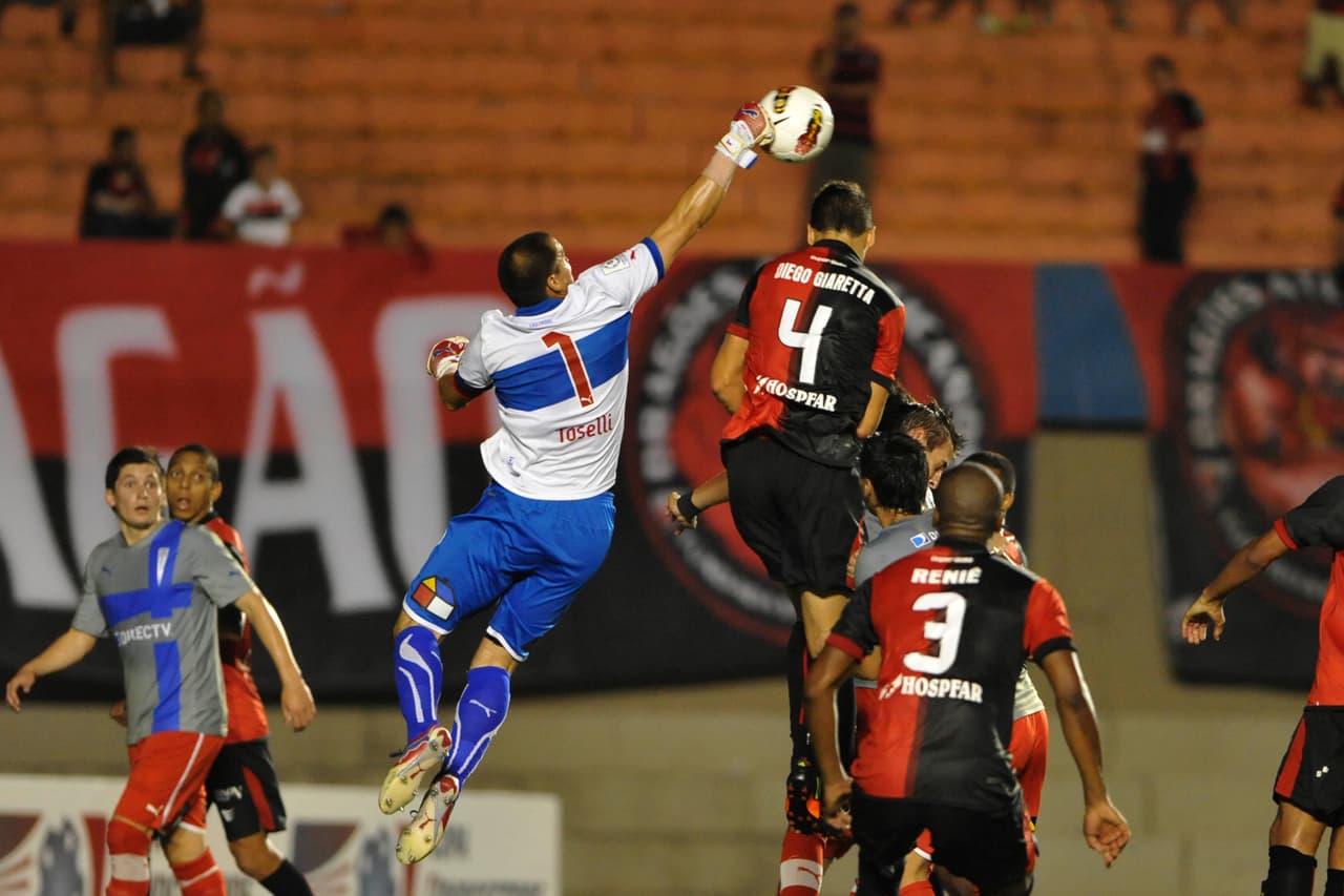 GOIÂNIA, BRAZIL - OCTOBER 24: Diego Giaretta (#4) of Atlético - GO fights for the ball with Cristopher Toselli (#1) of Universidad Católica during the match between Atlético GO from Brazil and Universidad Católica from Chile as part of the eighth stage of Copa Sudamericana 2012 at Serra Dourada stadium on October 24, 2012 in Goiânia, Brazil. (Photo by Eduardo Efrain/LatinContent/Getty Images)