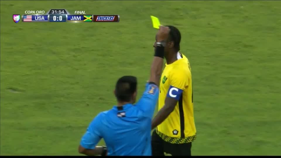 Tarjeta amarilla. El árbitro amonesta a Darren Mattocks de Jamaica