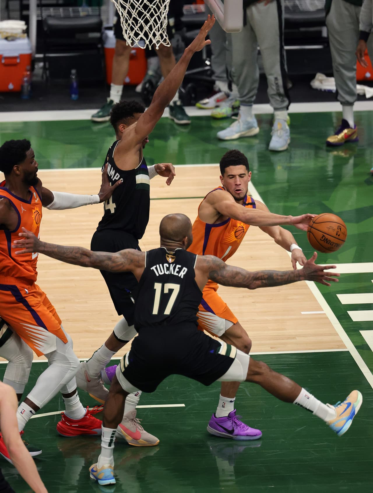 Devin Booker # 1 de los Phoenix Suns pasa contra P.J. Tucker # 17 de los Milwaukee Bucks durante la primera mitad del Juego.