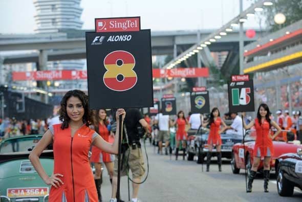 Las modelos engalanaron un desfile con autos antiguos antes del inicio de la carrera.