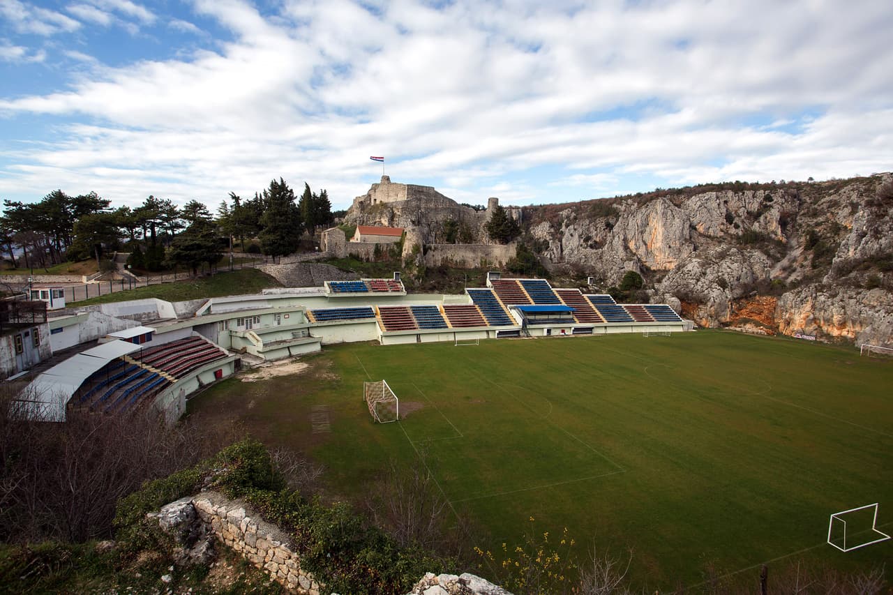 <b>Gospin Dolac Stadium (Croacia) -</b> Su ubicación es lo más extraño que tiene. Está entras las montañas y una de sus tribunas está cerca de un barranco de al menos 500 metros de alto.