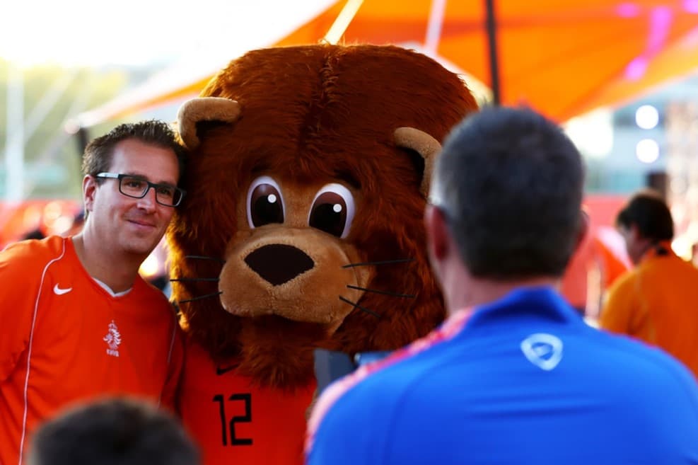 Los locales aprovechaban el tiempo previo para fotografiarse con la mascota de la Oranje.