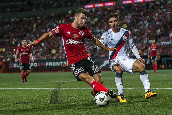 TIJUANA, MEXICO - JULY 29: Paul Arriola of Tijuana (L) fights for the ball with Isaac Brizuela of Chivas (R) during the 3rd round match between Tijuana and Chivas as part of the Torneo Apertura 2016 Liga MX at Caliente Stadium on July 29, 2016 in Tijuana, Mexico. (Photo by Alejandra Vital/LatinContent/Getty Images)
