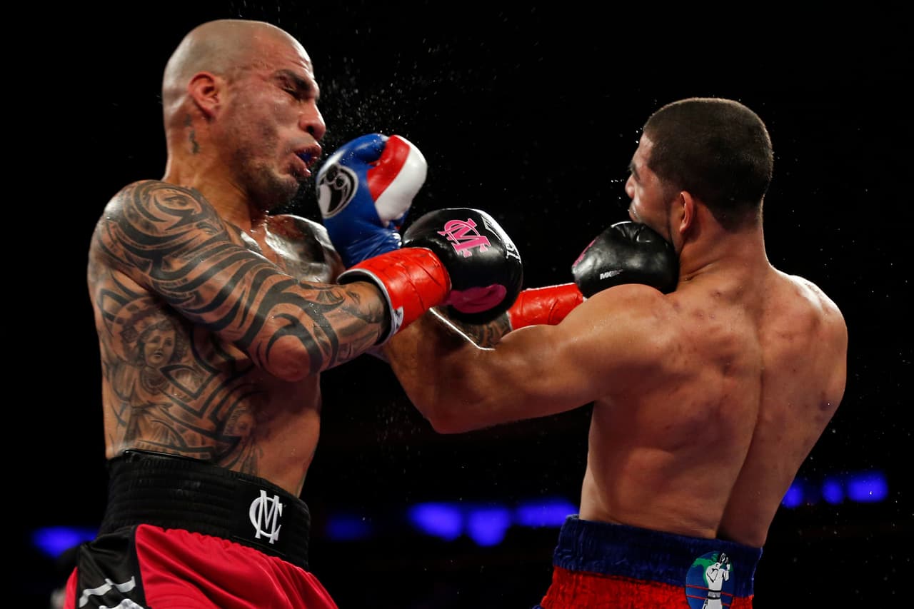 Miguel Cotto, left, of Puerto Rico, punches Sadam Ali, during the third round of a WBO junior middleweight title boxing match Saturday, Dec. 2, 2017, in New York. (AP Photo/Adam Hunger)