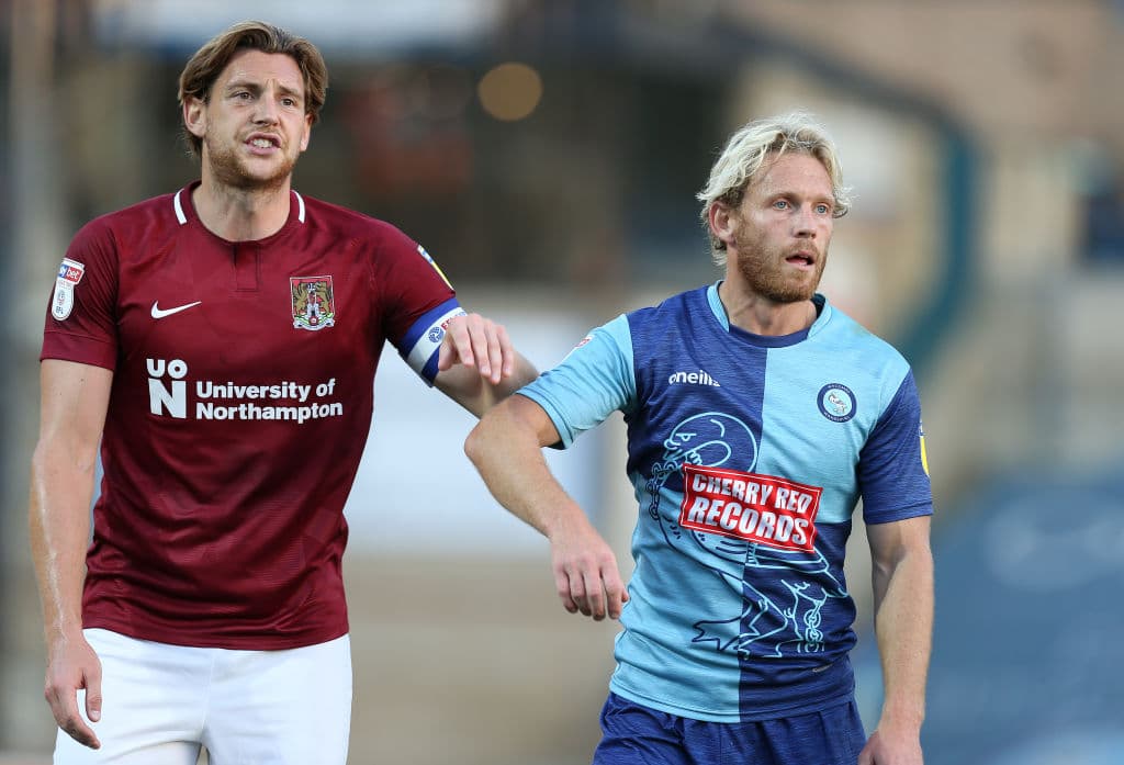 El segundo uniforme de los Wycombe Wanderers de la tercera división de Inglaterra (der) no parece esa pieza deportiva que quisieras tener.