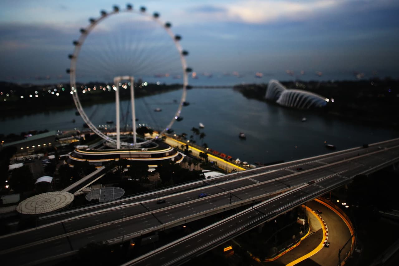 La belleza del paisaje hace que por poco pase desapercibido que en la pista del Gran Premio de Singapur está Nico Rosberg, en la parte inferior de la imagen. La exposición de contraste y color.
