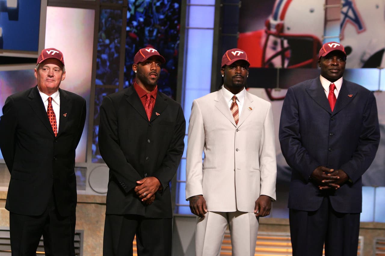 2001 MICHAEL VICK | QB Virginia Tech - 
<b>Atlanta Falcons</b>
<br>
<br>El quarterback Michael Vick junto a exmiembros de Virginia Tech, el head coach Frank Beamer, DeAngelo Hall y Bruce Smith, antes de ser presentado como jugador de los Atlanta Falcons por el comisionado de la NFL, Paul Tagliabue, con la selección número 1 del draft de la NFL el sábado 21 de abril de 2001 en Nueva York.