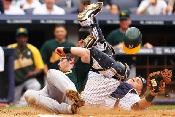 Russell Martin de los Yanquis aguanta el encontronazo con Eric Sogard para sacar el out en home.